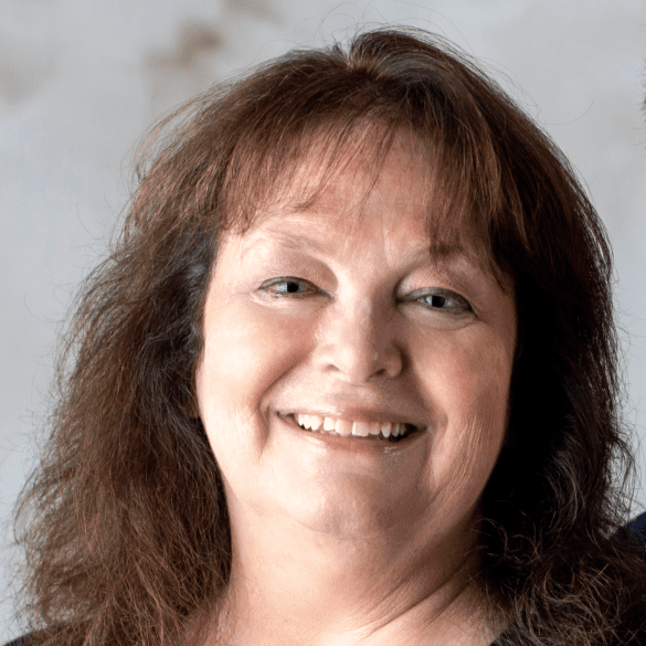 A woman with long hair smiles for the camera.