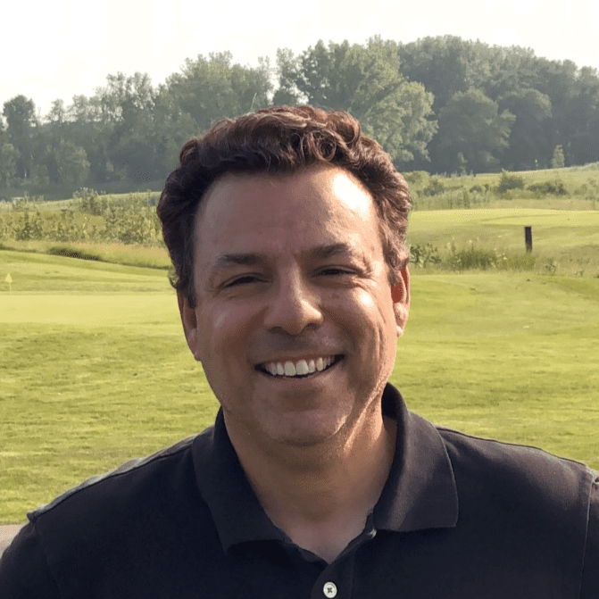 A man in black shirt smiling for the camera.